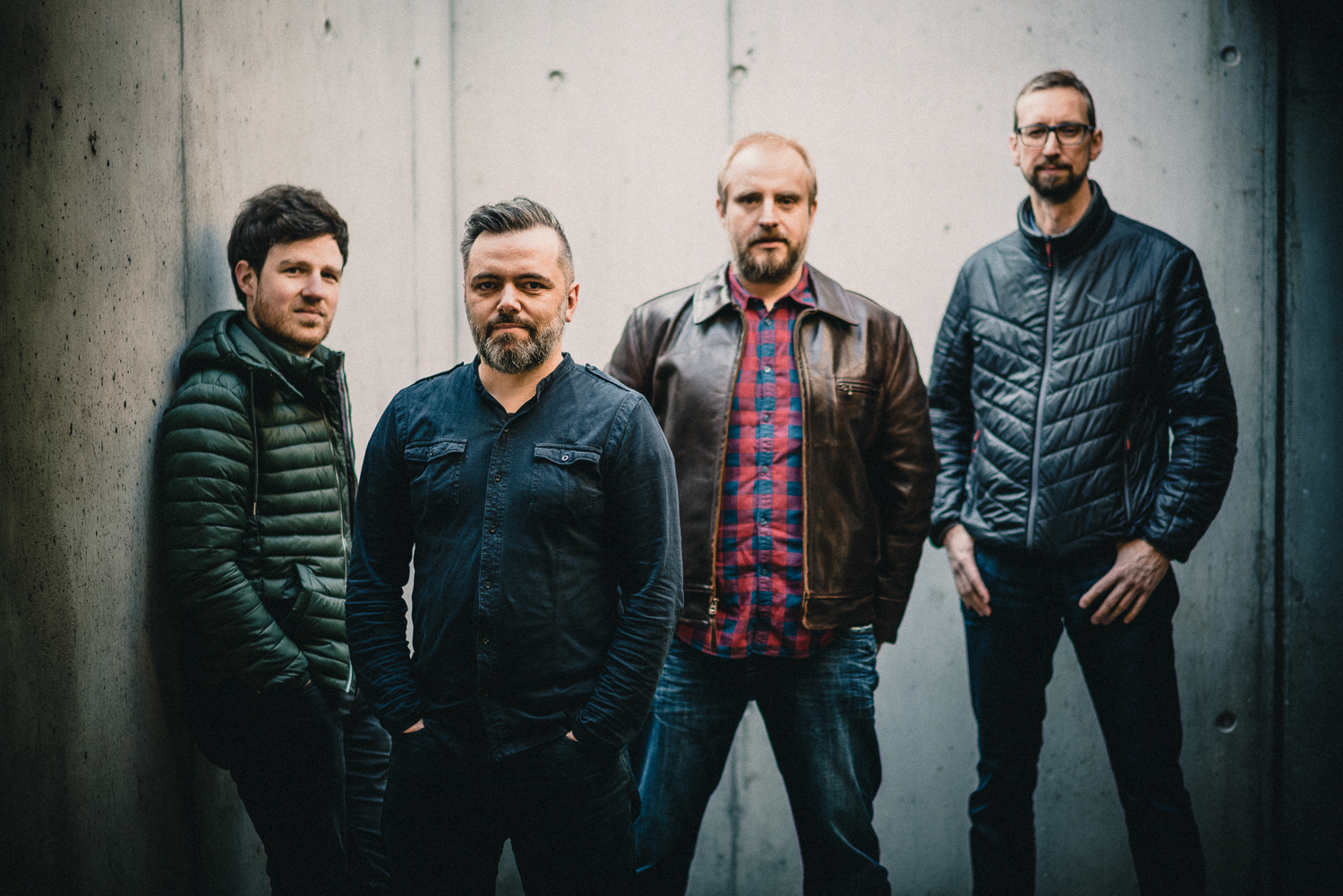 Die vier Musiker der Claudius Konrad Band vor einer Betonwand